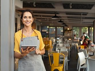 Female owner of small business stands in doorway